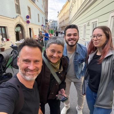 Helge Langer macht ein Selfie mit drei Besucher:innen des PARK(ing) Day in einer Altstadtgasse
